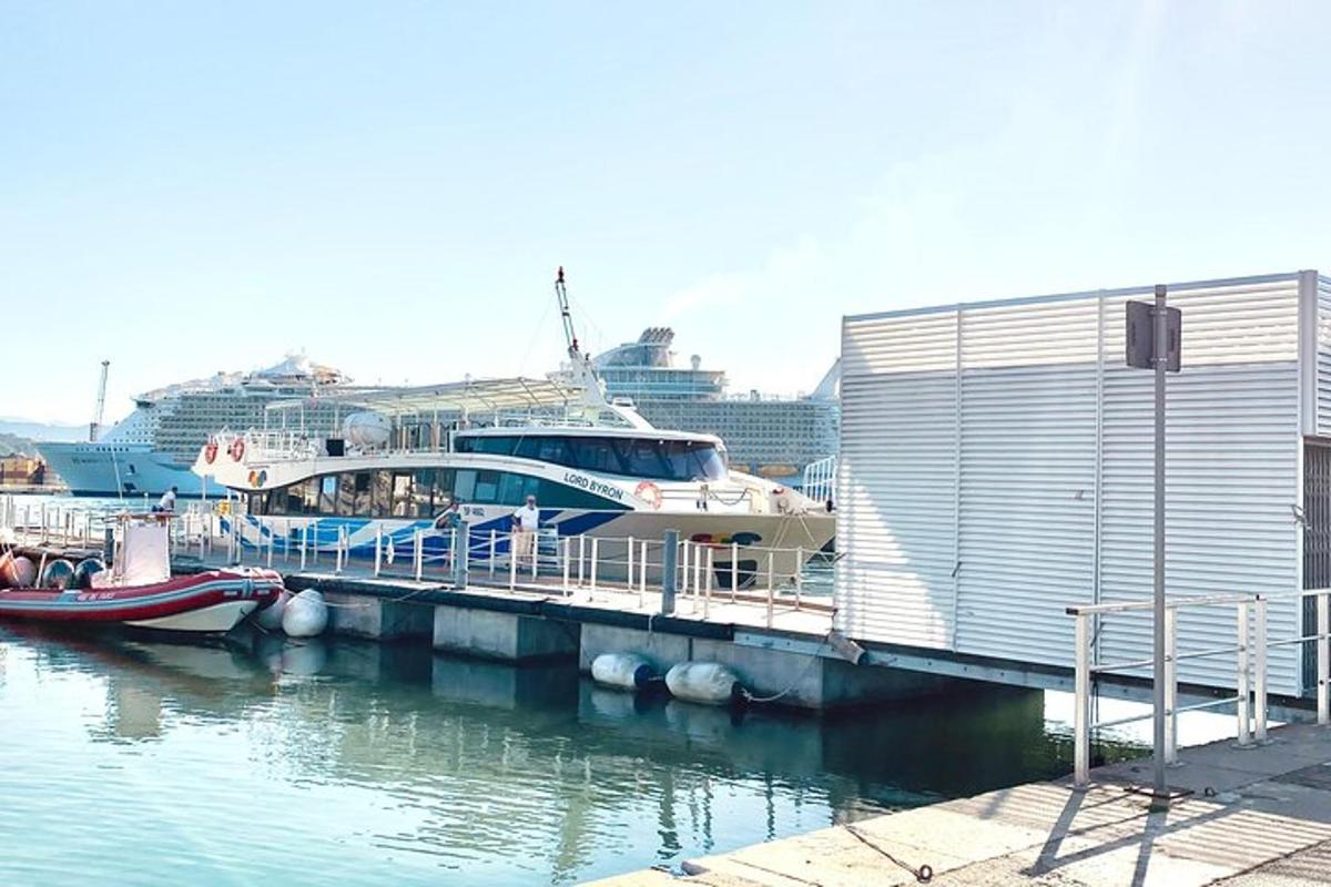 een boot aangemeerd aan een steiger met een cruiseschip
