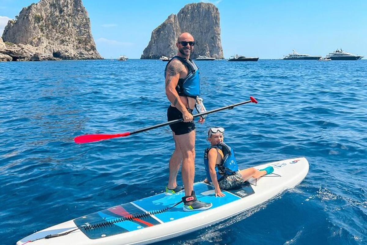 due uomini sono in piedi su una tavola da paddle in acqua