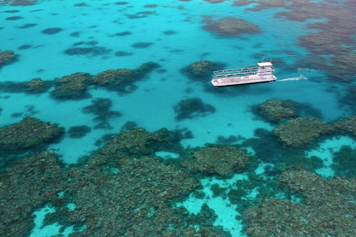 a boat floating in the water next to a reef