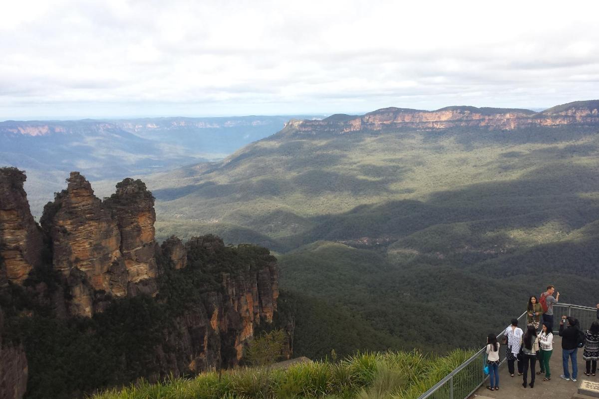 a group of people standing on the edge of a viewingvisor in the blue mountains