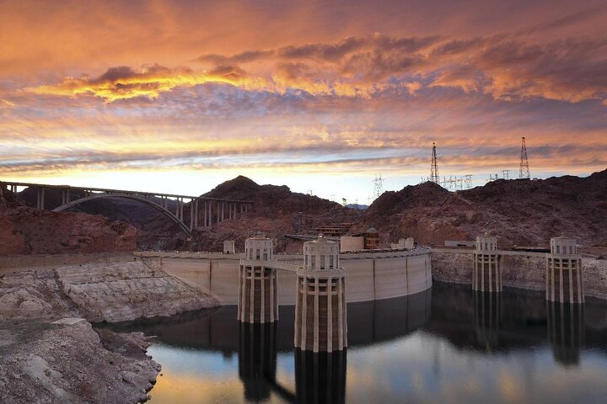 a dam in the middle of a river at sunset