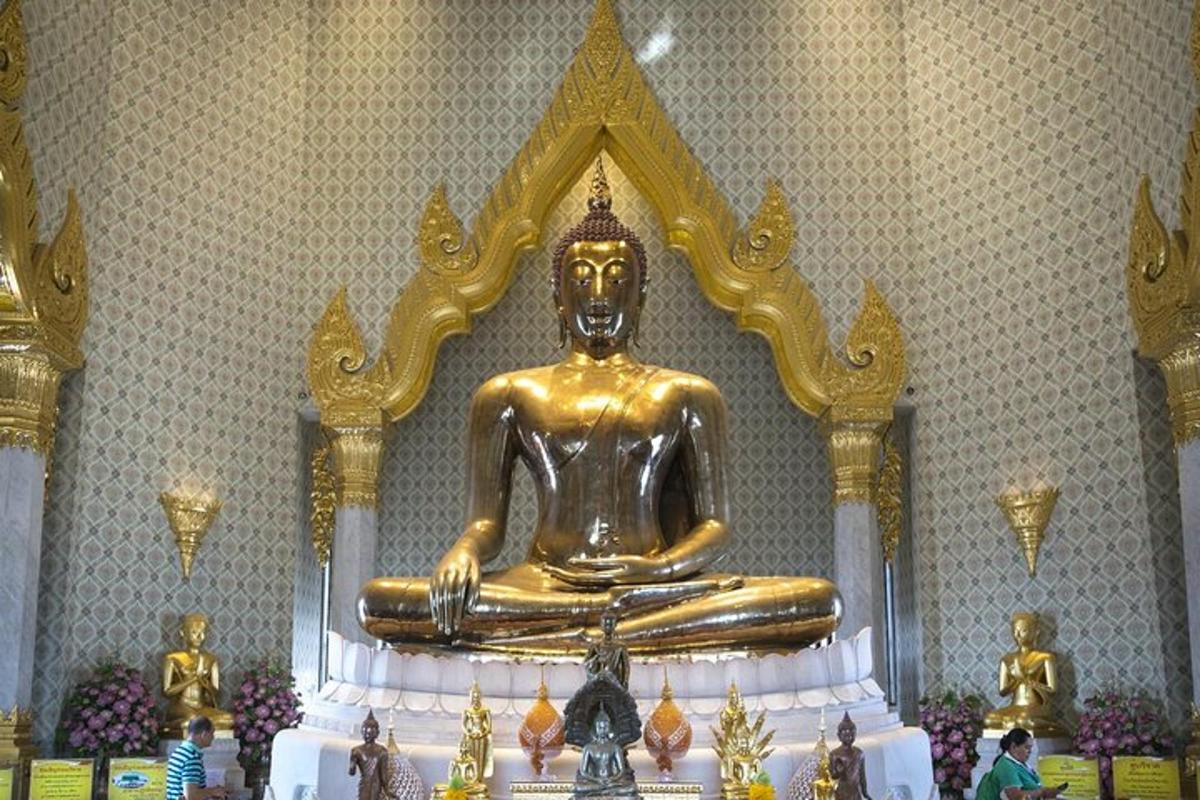 uma grande estátua dourada de Buda em uma sala