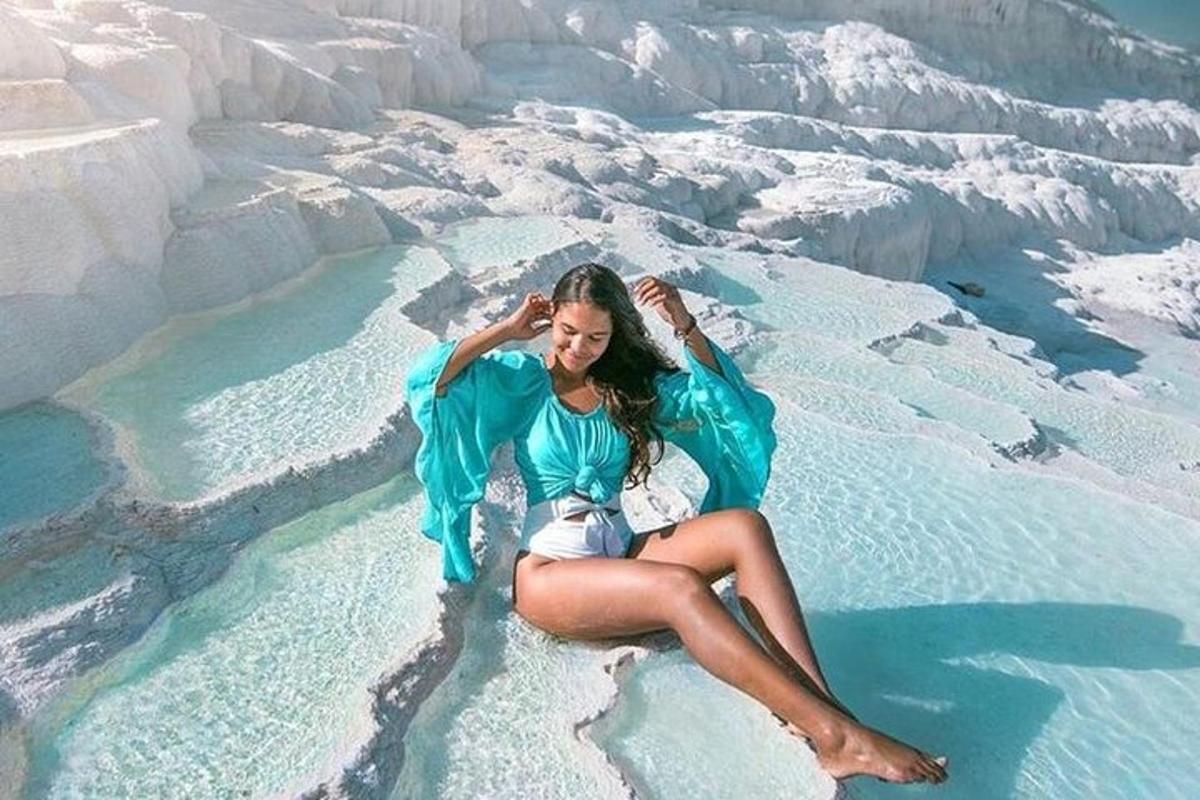 una mujer sentada en una roca en el agua