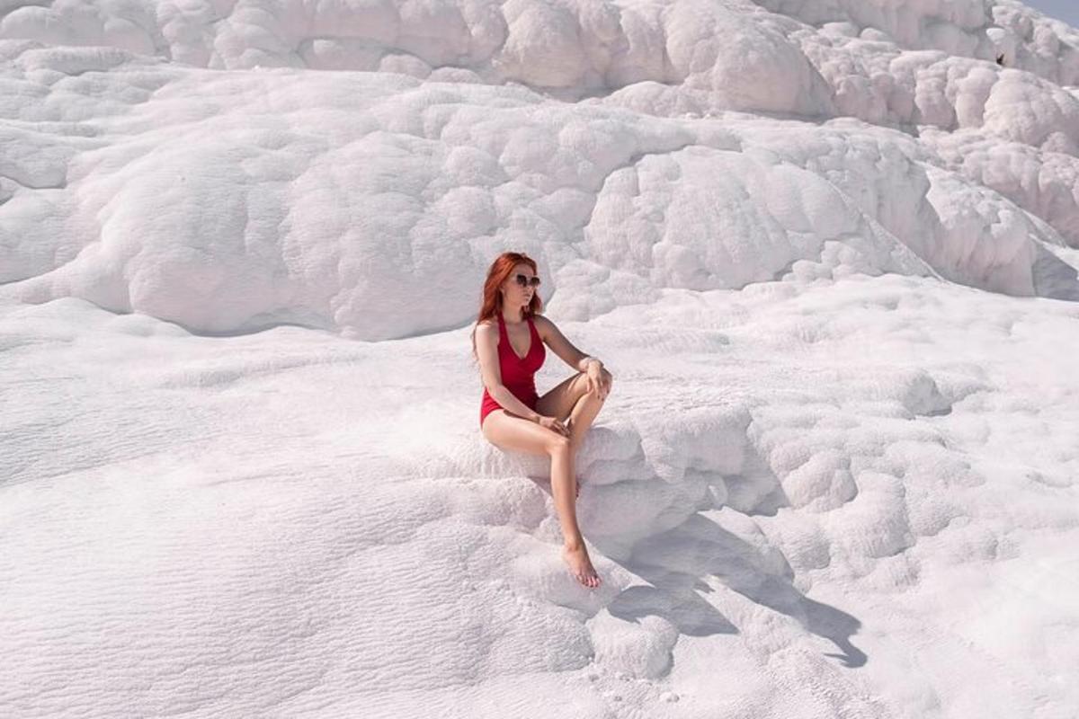 Una mujer en bikini rojo sentada en la nieve