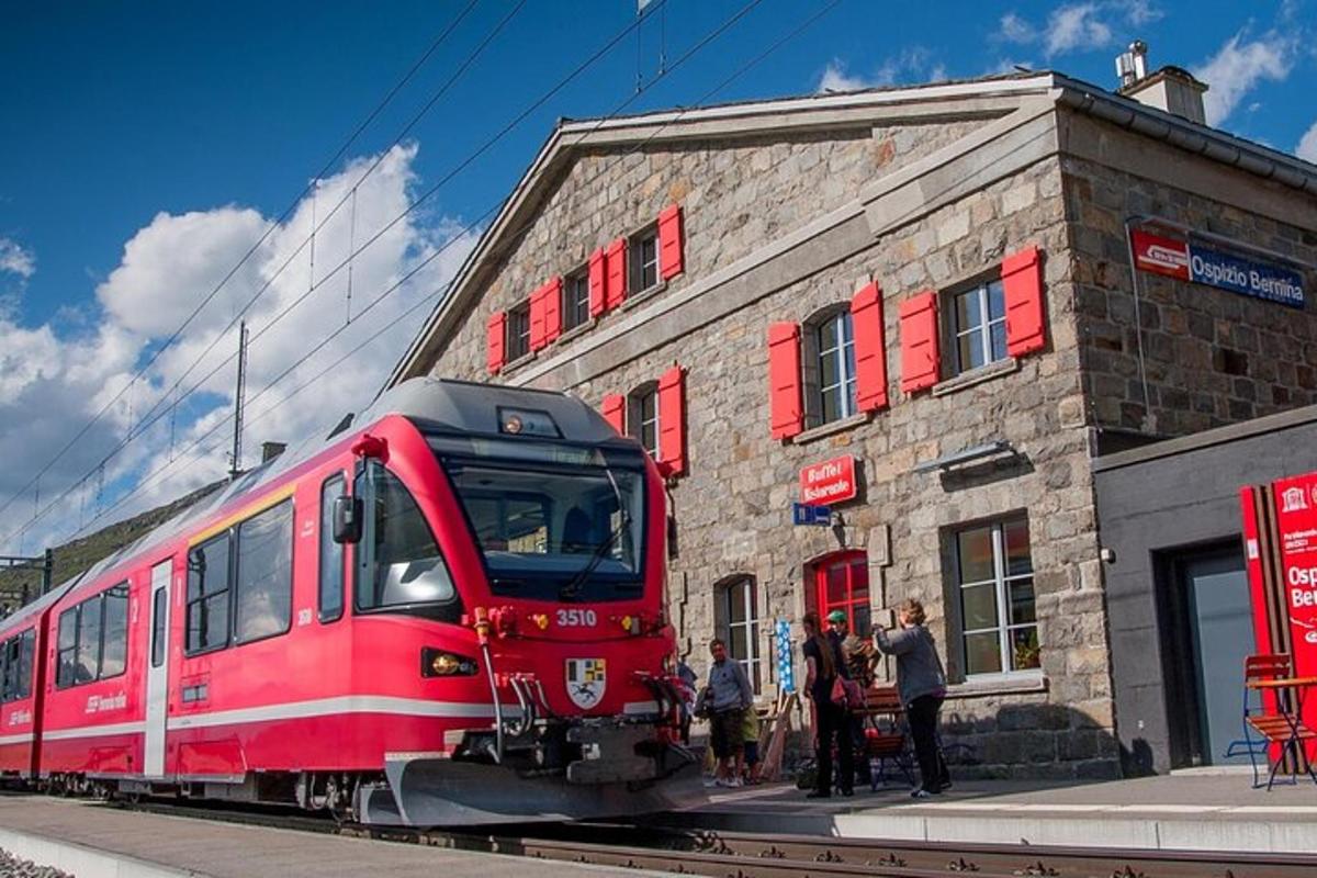 un treno rosso parcheggiato davanti a un edificio in mattoni