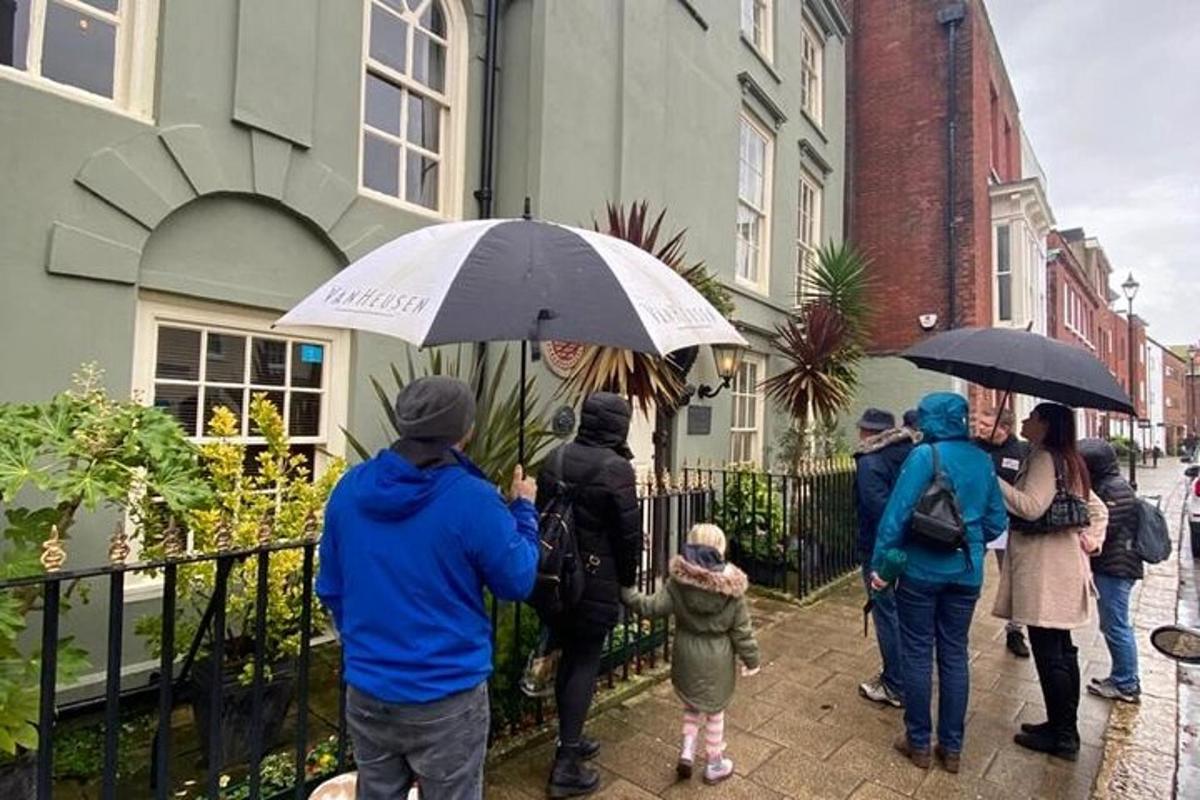 a group of people walking down a sidewalk with umbrellas