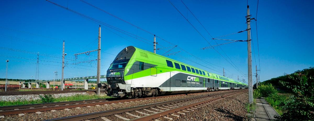 a green and white train on the tracks