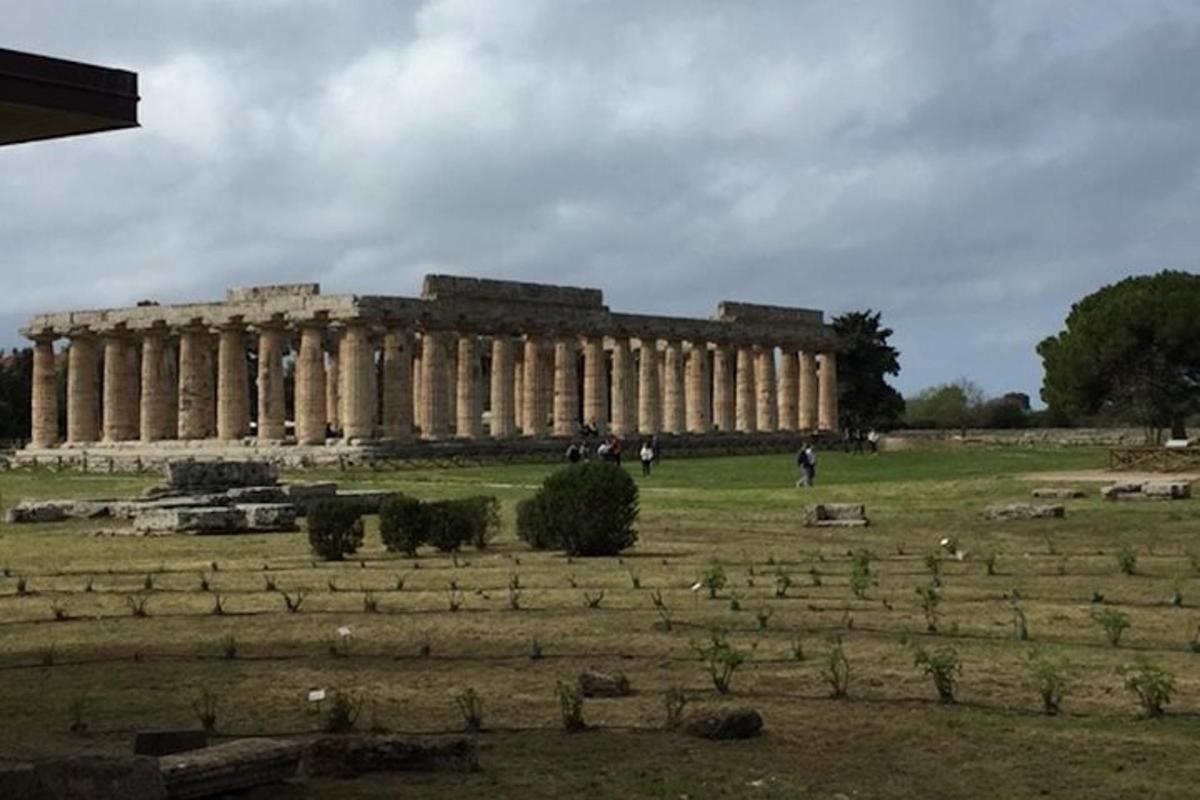 un gran edifici en un camp amb gent al davant