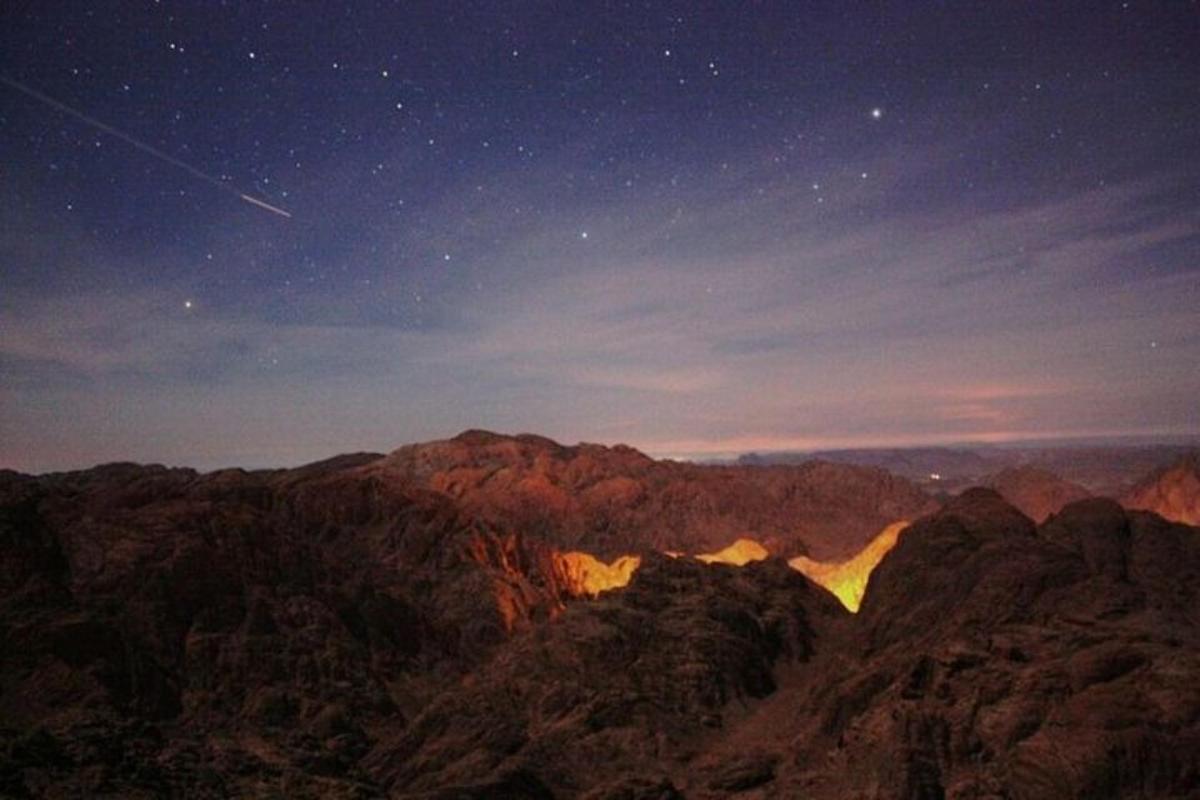 een uitzicht op een berg 's nachts met sterren