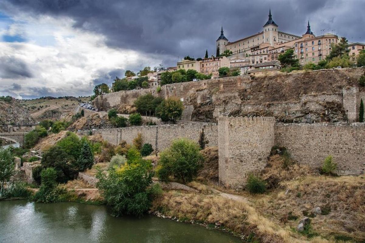 un gran edificio en la cima de una colina junto a un río