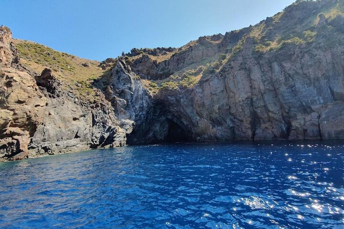 a large body of water next to a rocky cliff