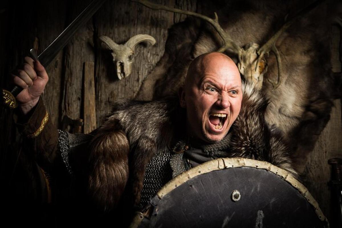 maður í brynju heldur á trommu með opinn munn