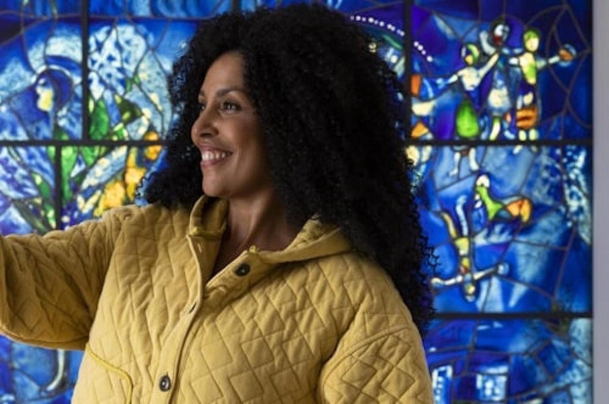 a woman standing in front of a stained glass window