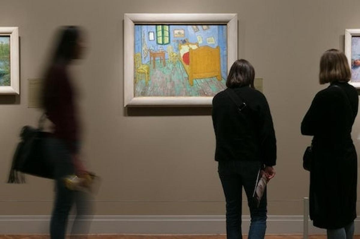 a group of people looking at an art exhibit