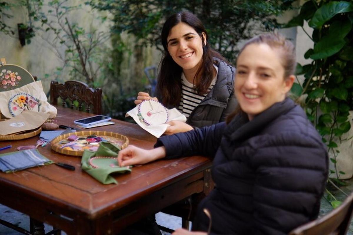 duas mulheres sentadas à mesa com um bolo