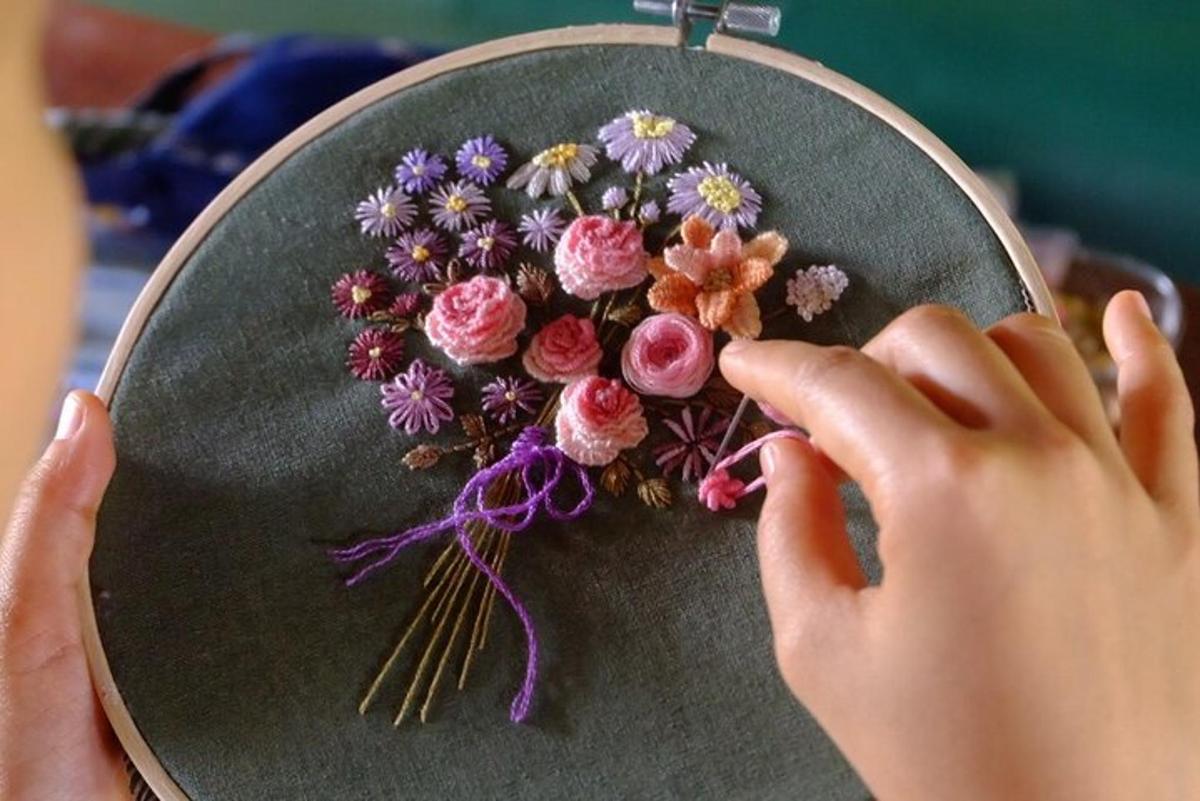 uma pessoa está fazendo um buquê de flores sobre uma mesa