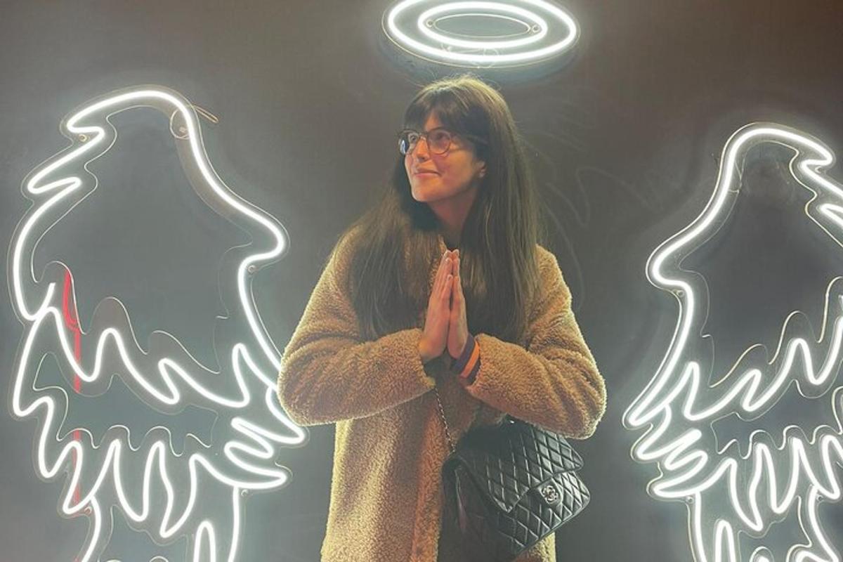 a woman standing in front of a neon sign