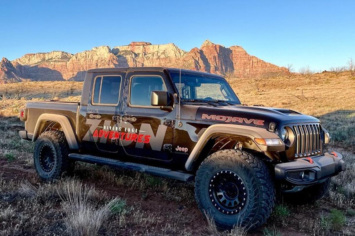 a jeep parked in a field in the desert