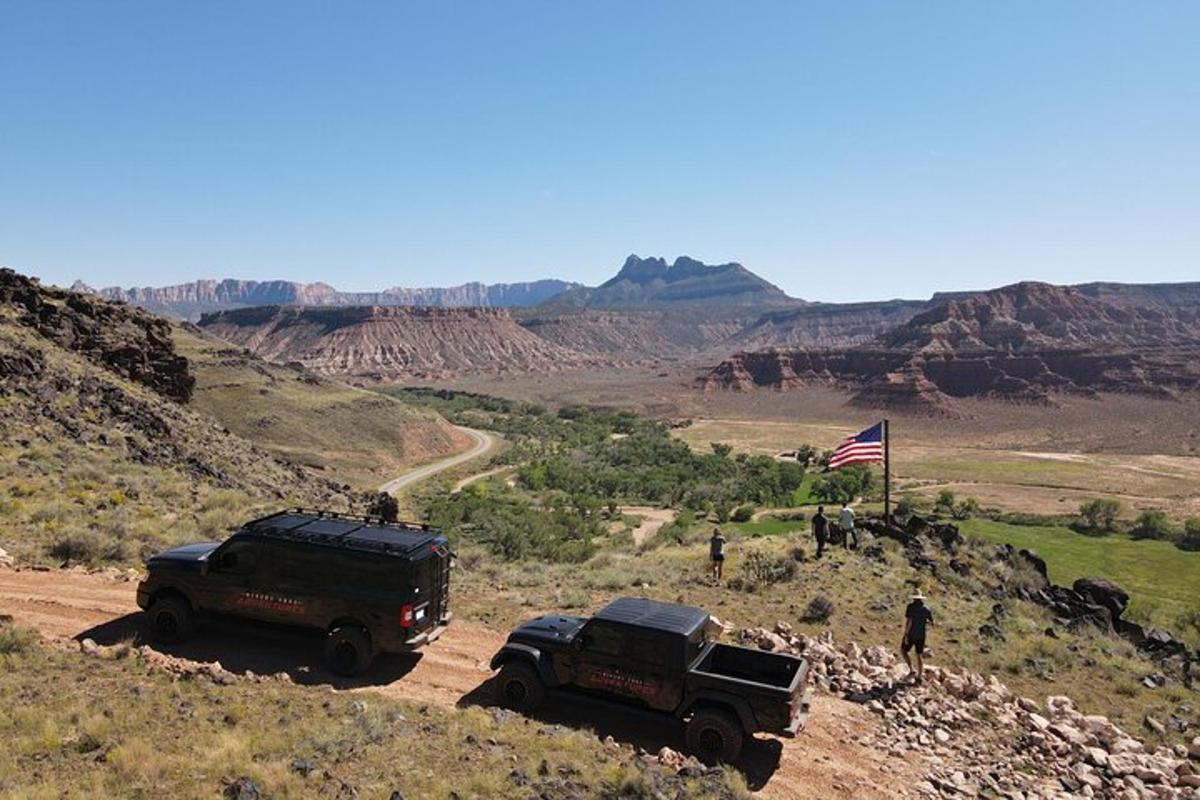 two trucks parked on a dirt road in the desert