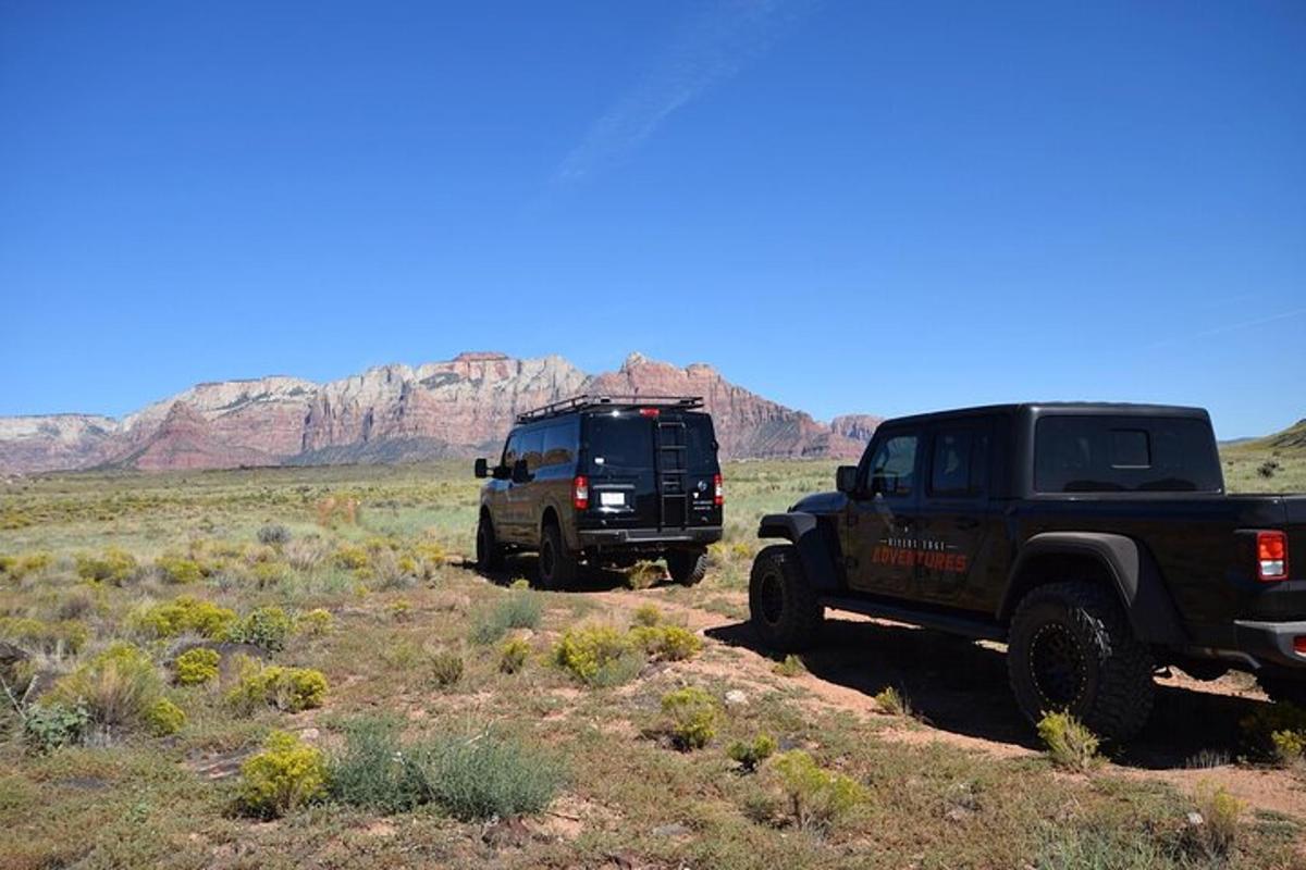 two trucks parked on a dirt road in the desert