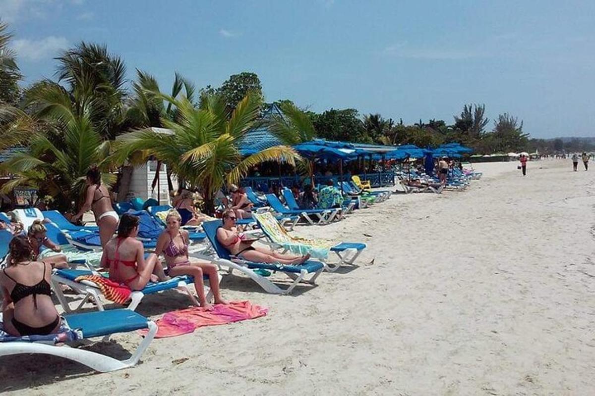 um grupo de pessoas sentadas em cadeiras de jardim na praia