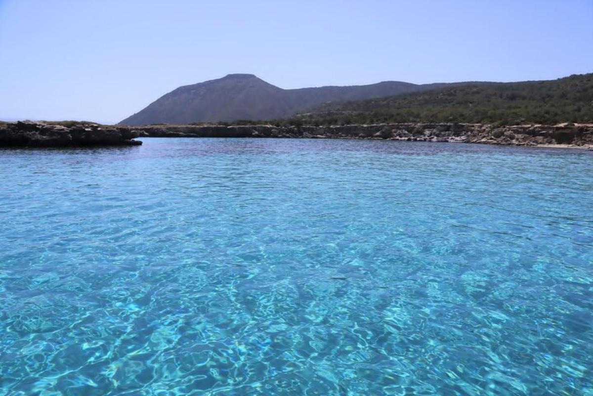 un grande specchio d'acqua blu con le montagne sullo sfondo