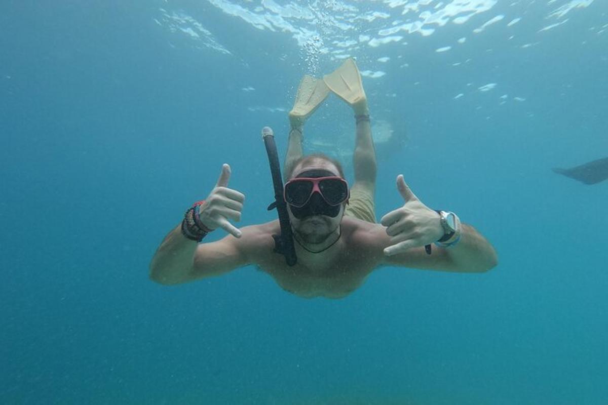 a man is swimming in the water with a bottle