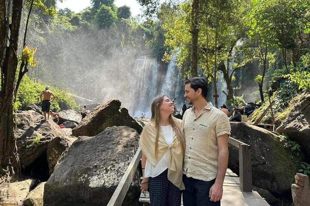 un uomo e una donna in piedi davanti a una cascata