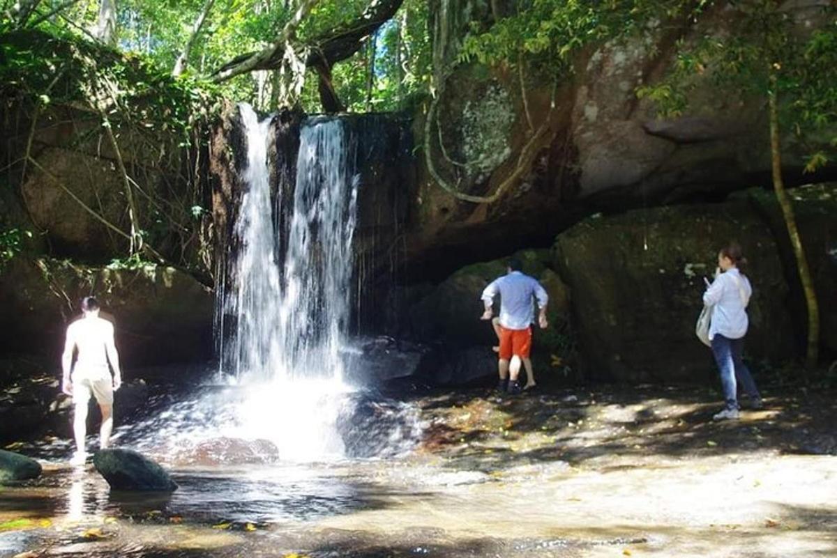 tre persone in piedi davanti a una cascata