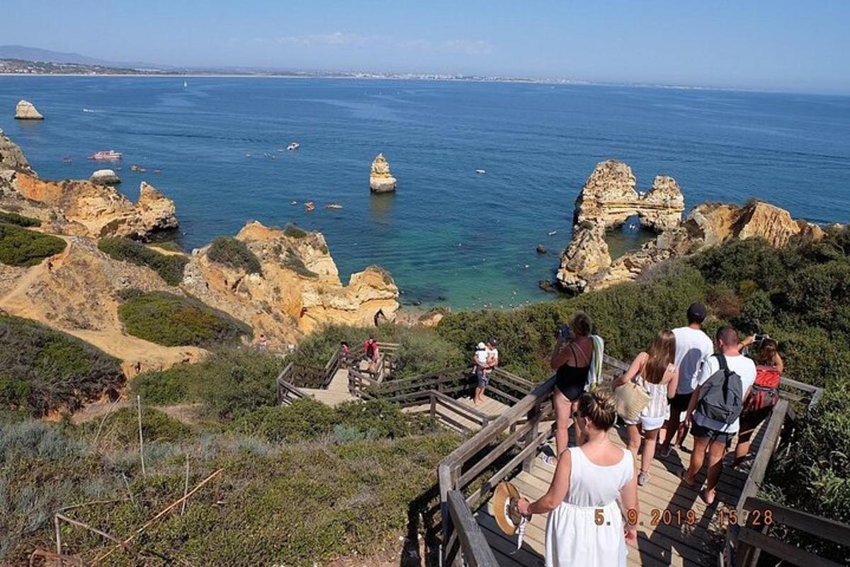 un gruppo di persone in piedi su una scalinata che guarda l'oceano