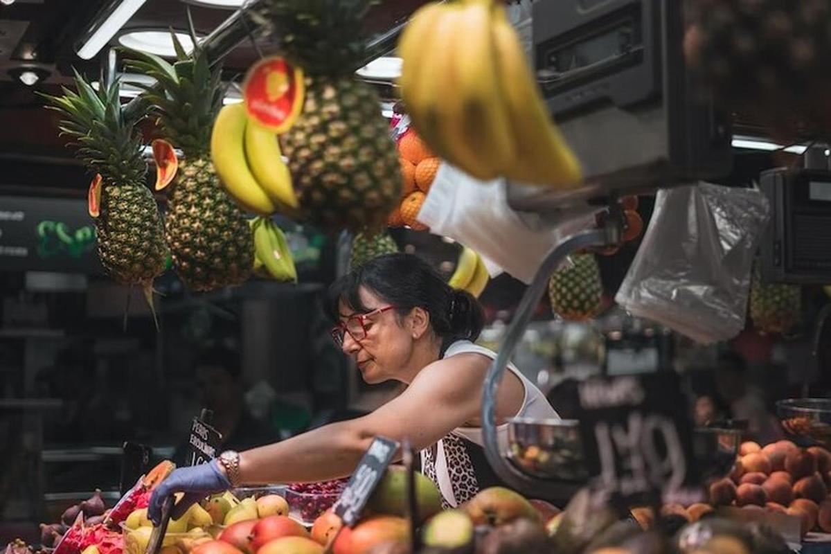 seorang wanita yang bekerja di pasar dengan buah-buahan dan sayur-sayuran