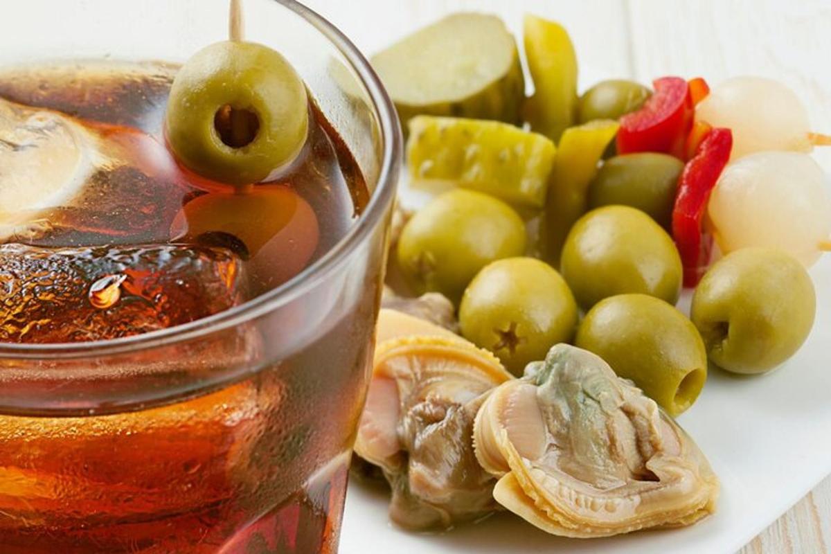 um copo de líquido ao lado de um grupo de frutas