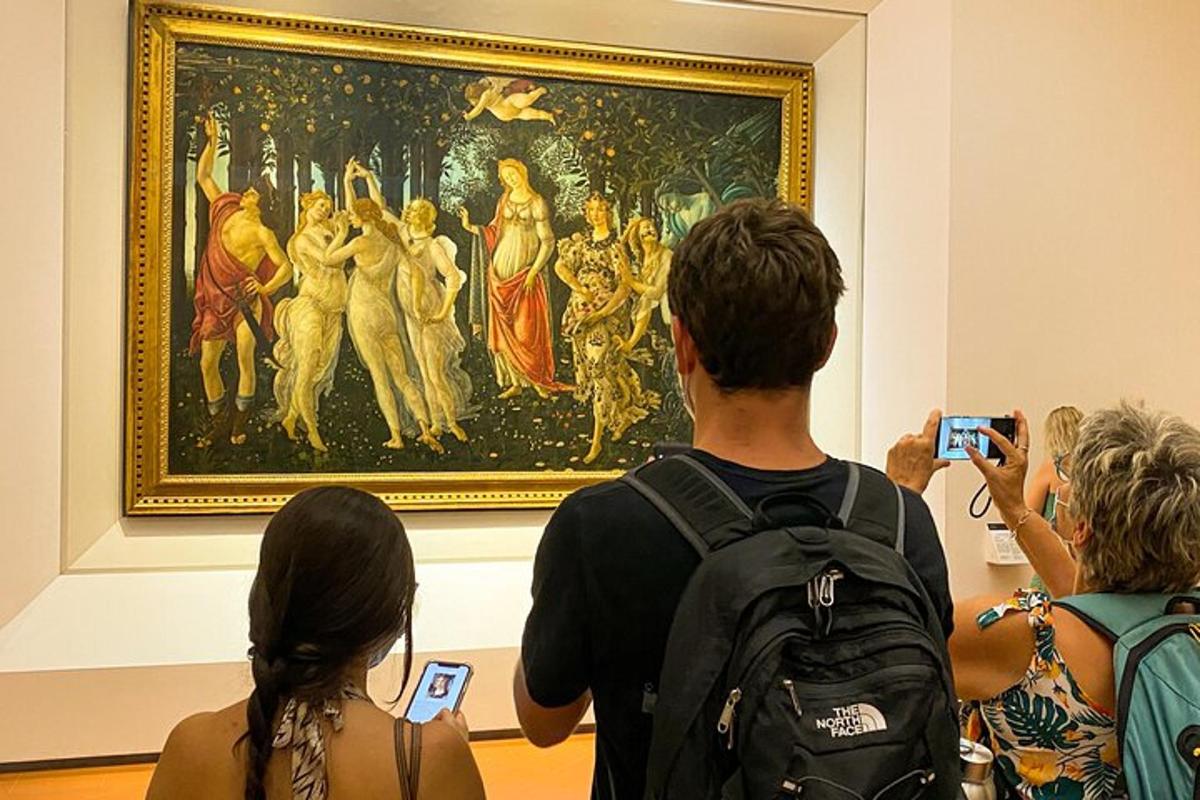 um grupo de pessoas tirando fotos de uma pintura