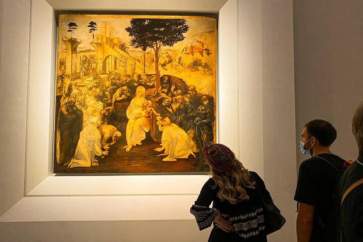 um grupo de pessoas olhando para uma pintura em um museu