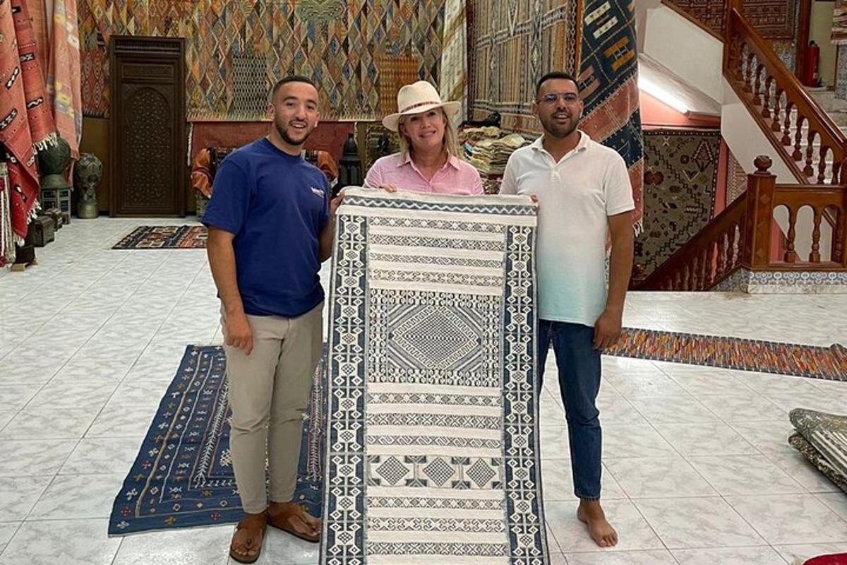 dois homens e uma mulher em pé ao lado de um artefato