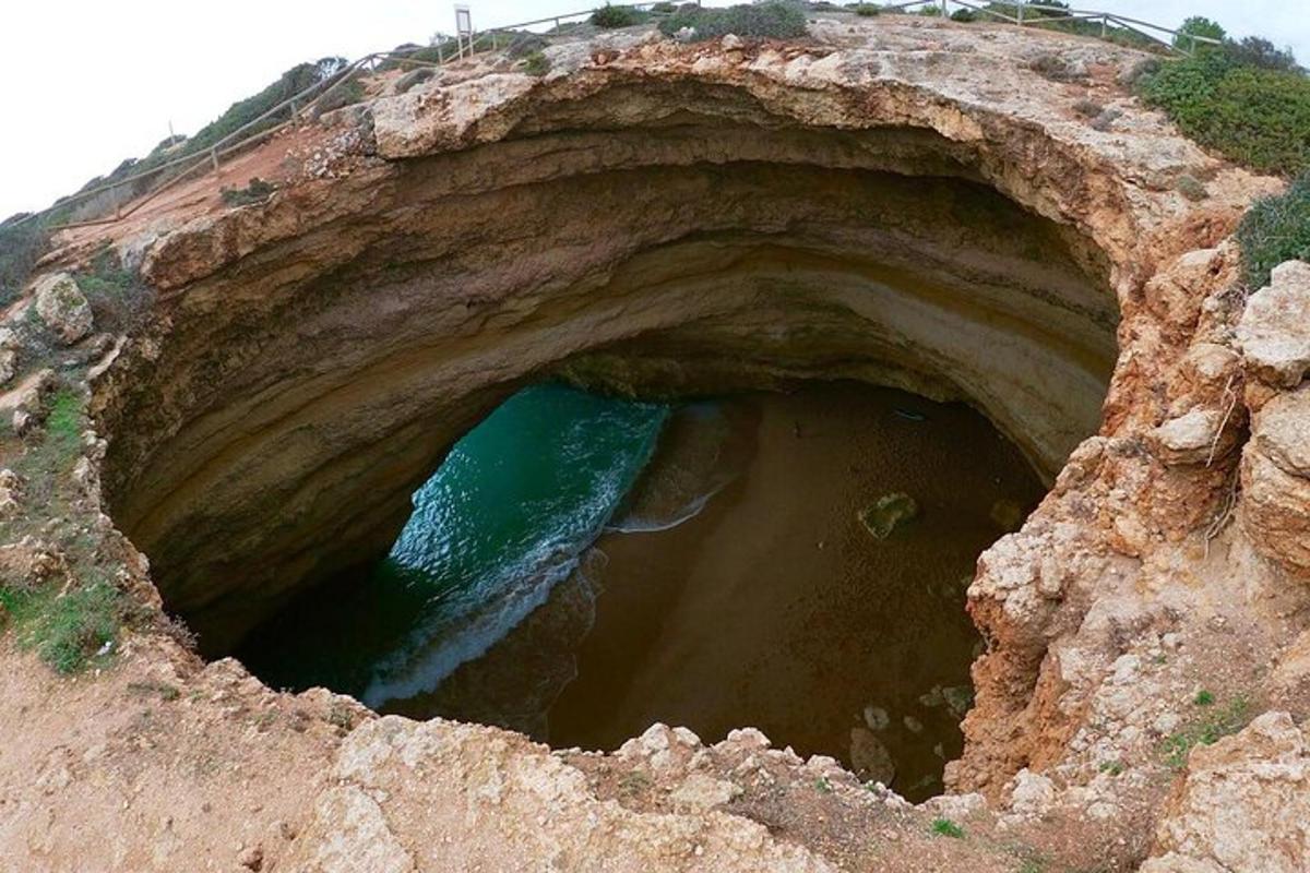 a large rock cave with water inside of it