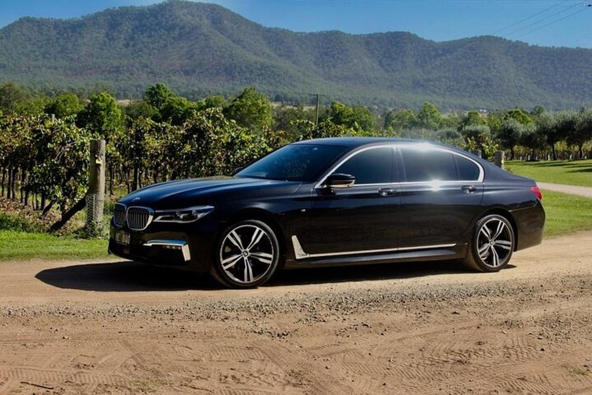 une voiture noire garée sur un chemin de terre