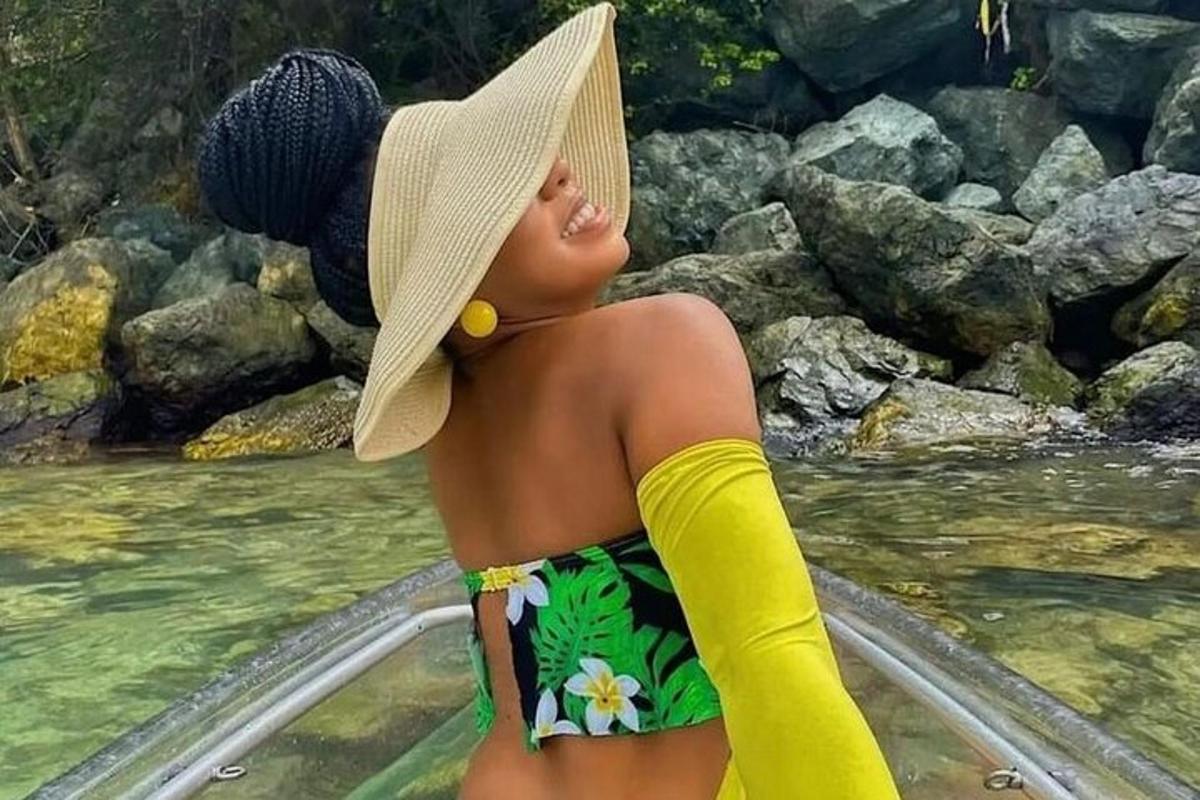 a young girl wearing a hat standing in the water