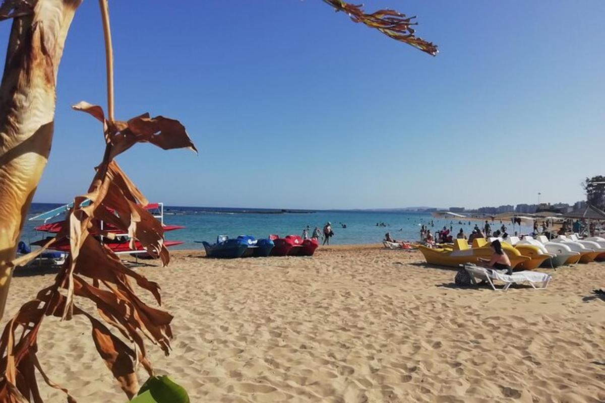 uma praia com um monte de gente e barcos