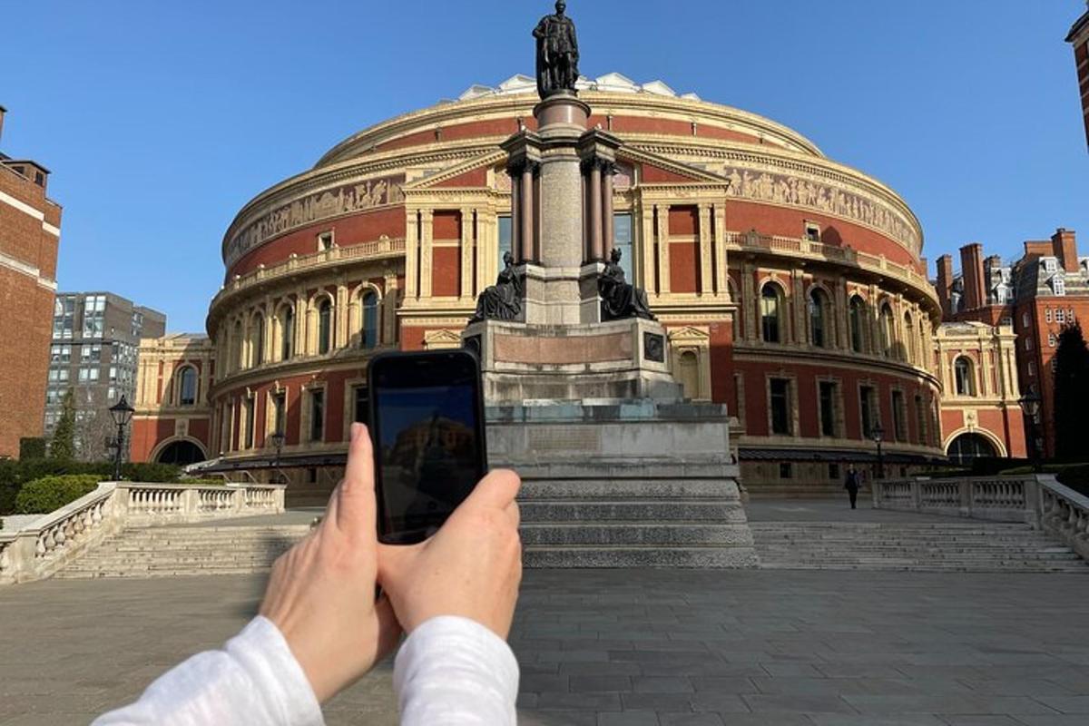 una persona tomando una fotografía de una estatua frente a un edificio