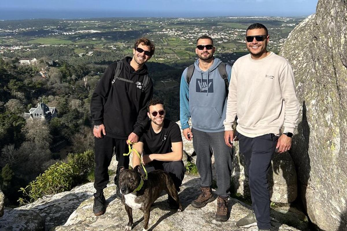 un gruppo di persone e un cane in piedi su una roccia