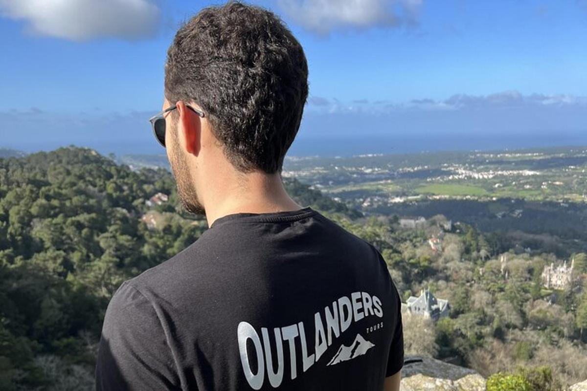 un uomo con una camicia nera in piedi sulla cima di una montagna