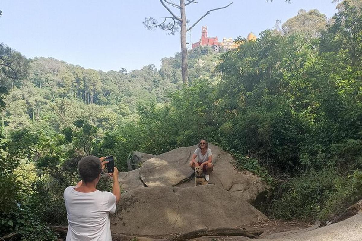 un home fent una foto d'un home assegut en una roca