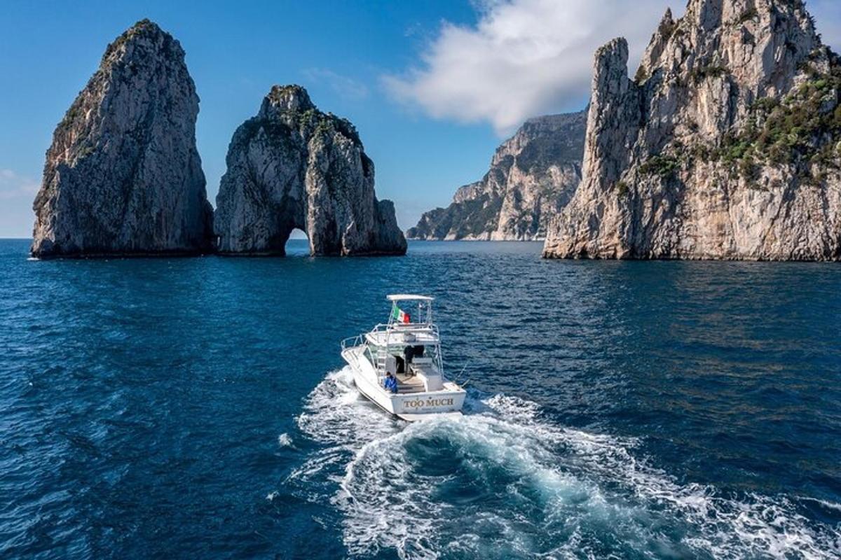 una barca in acqua vicino ad alcune grandi formazioni rocciose