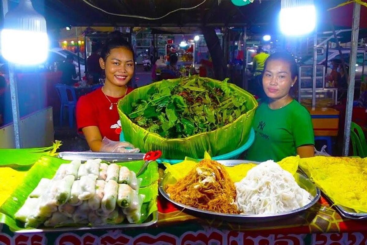 two women standing in front of a table with food
