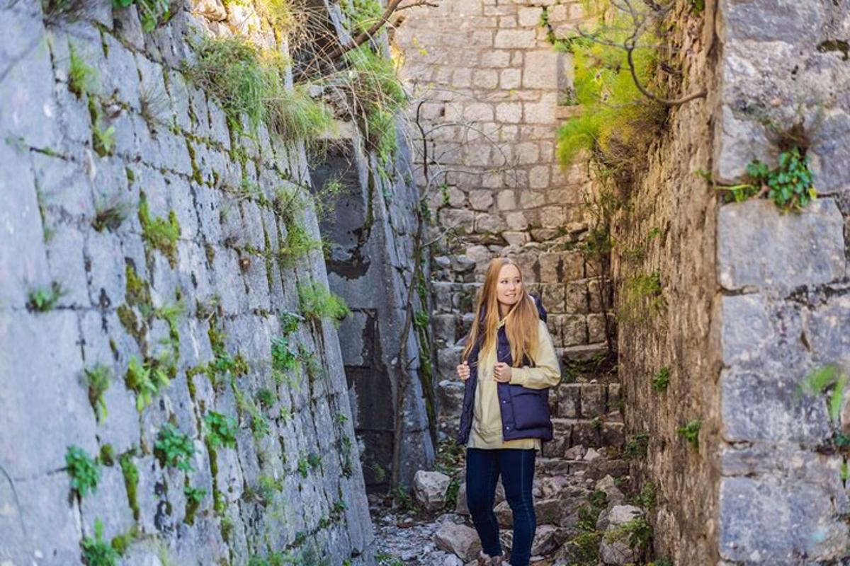 žena stojící v uličce vedle cihlové zdi