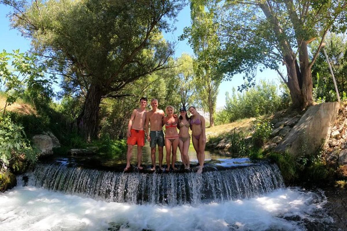 a group of people standing in front of a waterfall