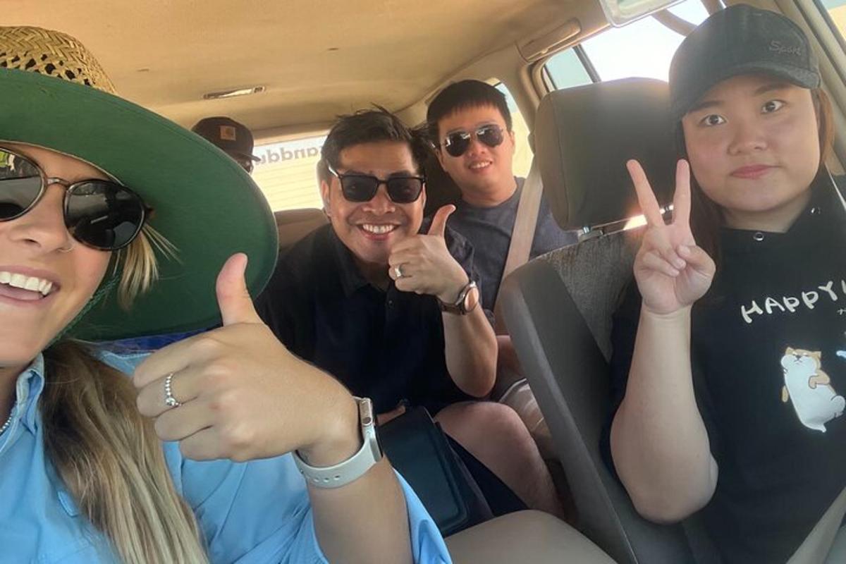 a group of people sitting in a van giving the peace sign