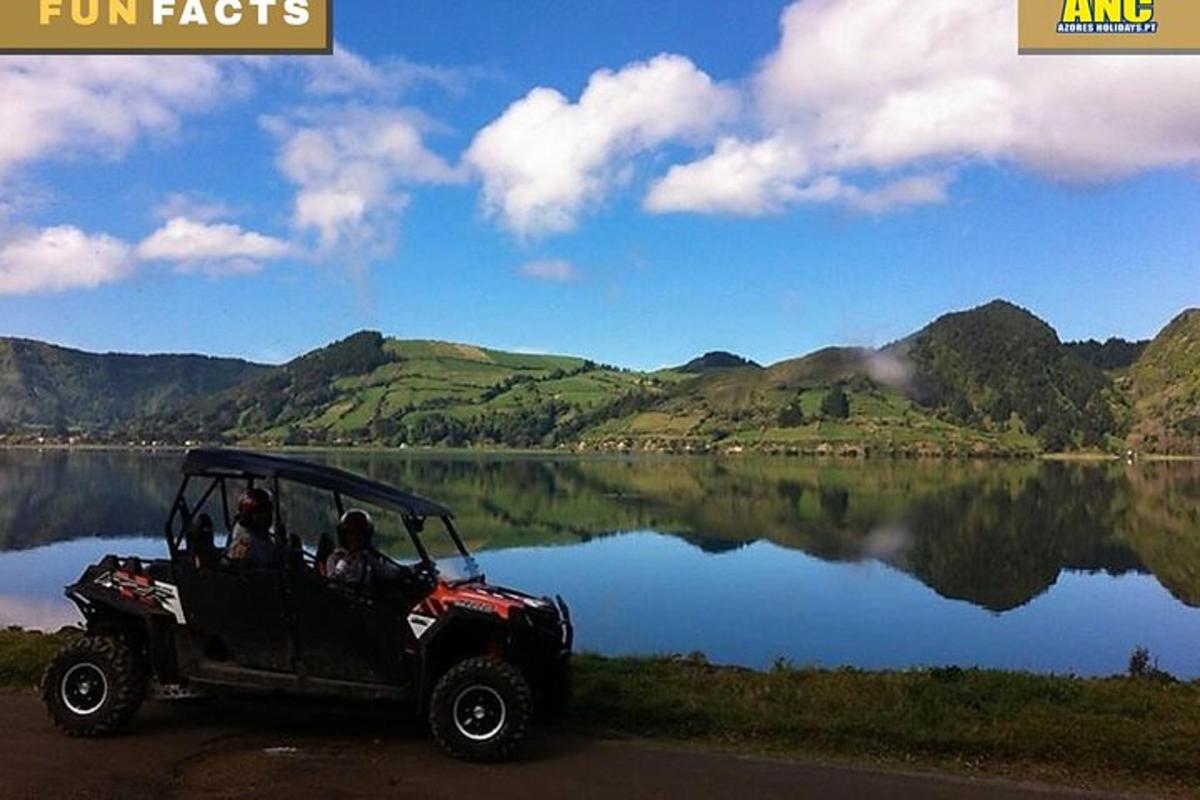 two people in a jeep parked next to a lake