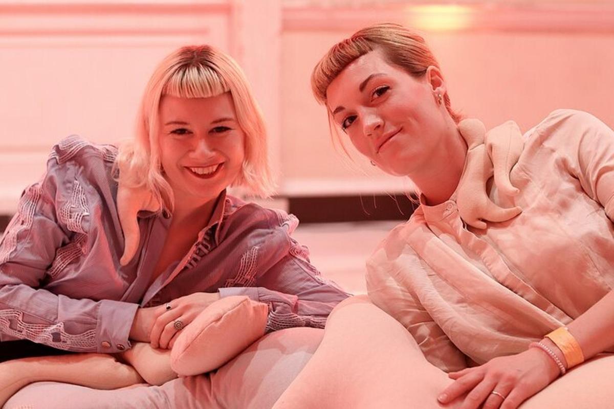 duas mulheres sentadas uma ao lado da outra em um sofá